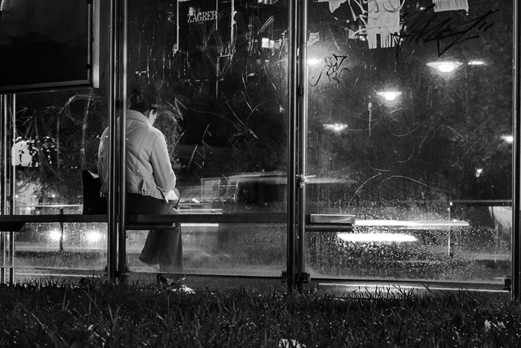 djevojka sjedi na stanici u jesensko večer 